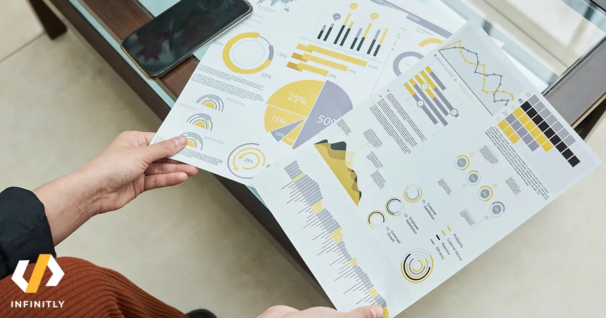 Close-up of businesswoman sitting at the table and examining financial report with graphs